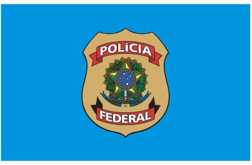 Brasão da Polícia Federal do Brasil sobre fundo azul. O distintivo dourado exibe o emblema nacional ao centro, com faixas vermelhas contendo as palavras "Polícia" acima e "Federal" abaixo.