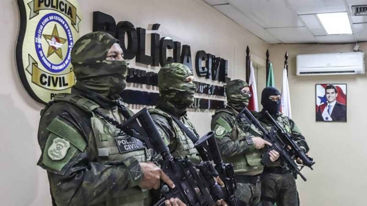 "Policiais civis fortemente armados e encapuzados, em fardas camufladas, posicionados dentro de uma delegacia da Polícia Civil do Pará."
