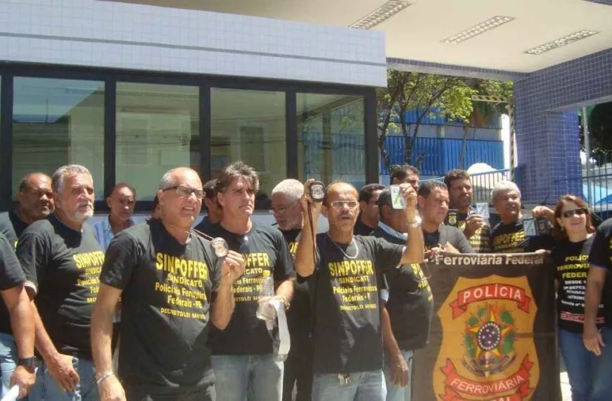 Polícia Ferroviária Federal: a polícia esquecida - Grupo de policiais ferroviários federais em manifestação, usando camisetas pretas do sindicato (SINPOFFER) e exibindo carteiras funcionais em frente a um prédio público.