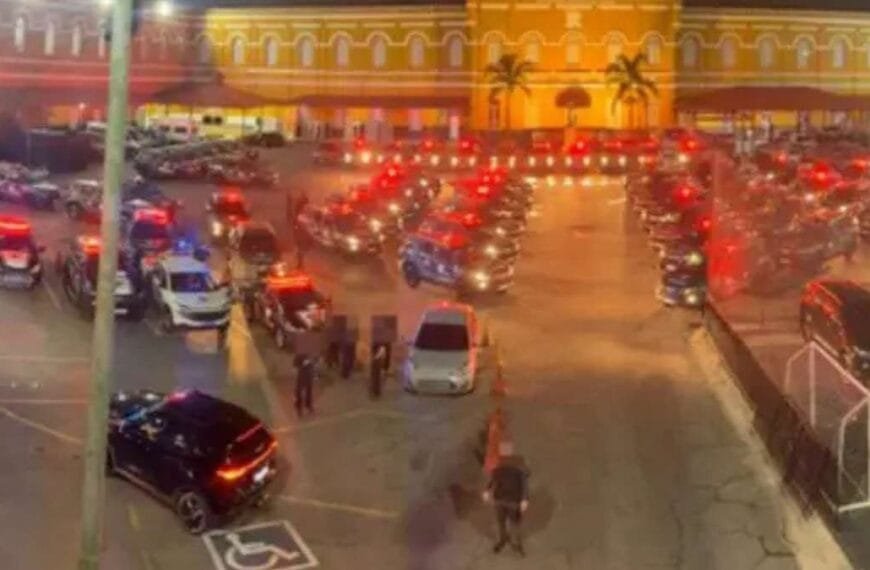 Operacao-Carbono-Oculto-somos-um-narcoestado - Viaturas da polícia alinhadas em pátio, com sirenes ligadas e agentes ao redor durante operação noturna.