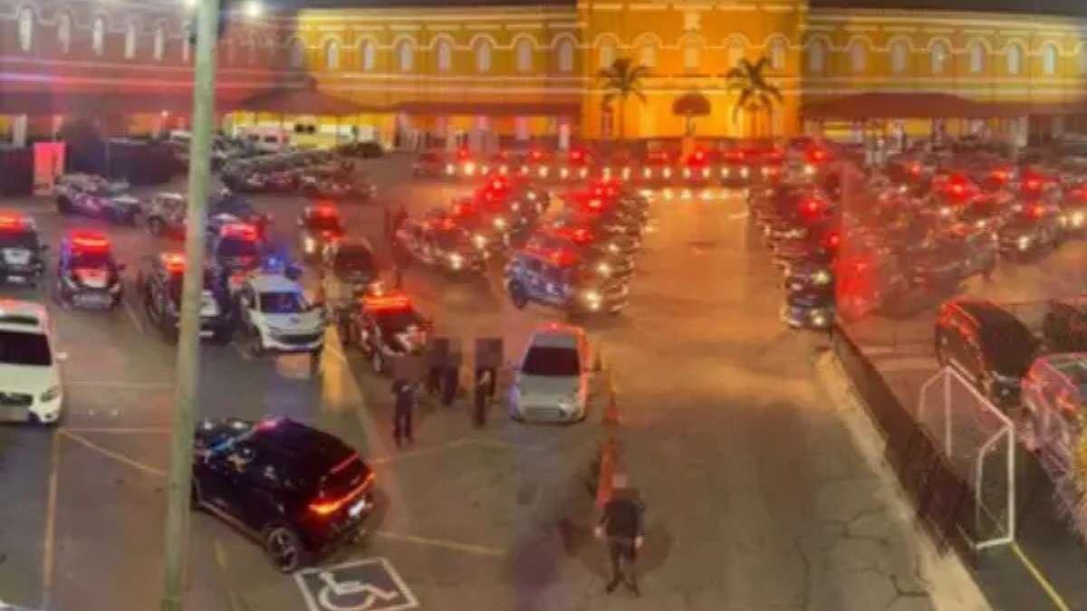 Operacao-Carbono-Oculto-somos-um-narcoestado - Viaturas da polícia alinhadas em pátio, com sirenes ligadas e agentes ao redor durante operação noturna.