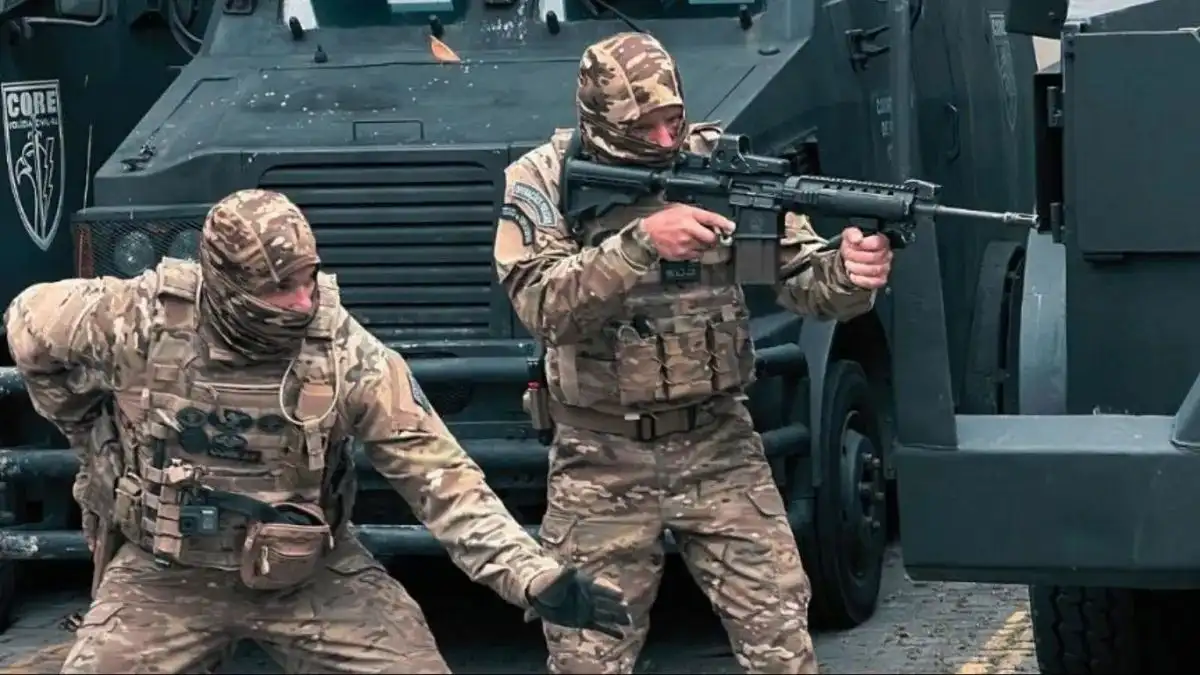 CORE neutraliza líder do TCP-Dois policiais da CORE, em uniforme camuflado e armados, posicionam-se ao lado de veículos blindados durante operação tática.
