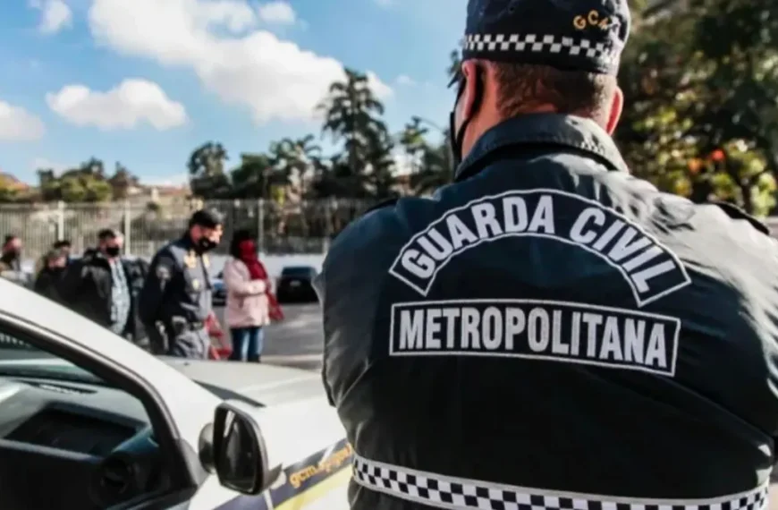 Leniência judicial impede combate ao crime pela GCM-Agente da Guarda Civil Metropolitana, de costas, próximo a uma viatura, acompanha ação em área urbana com outras pessoas e policiais ao fundo.