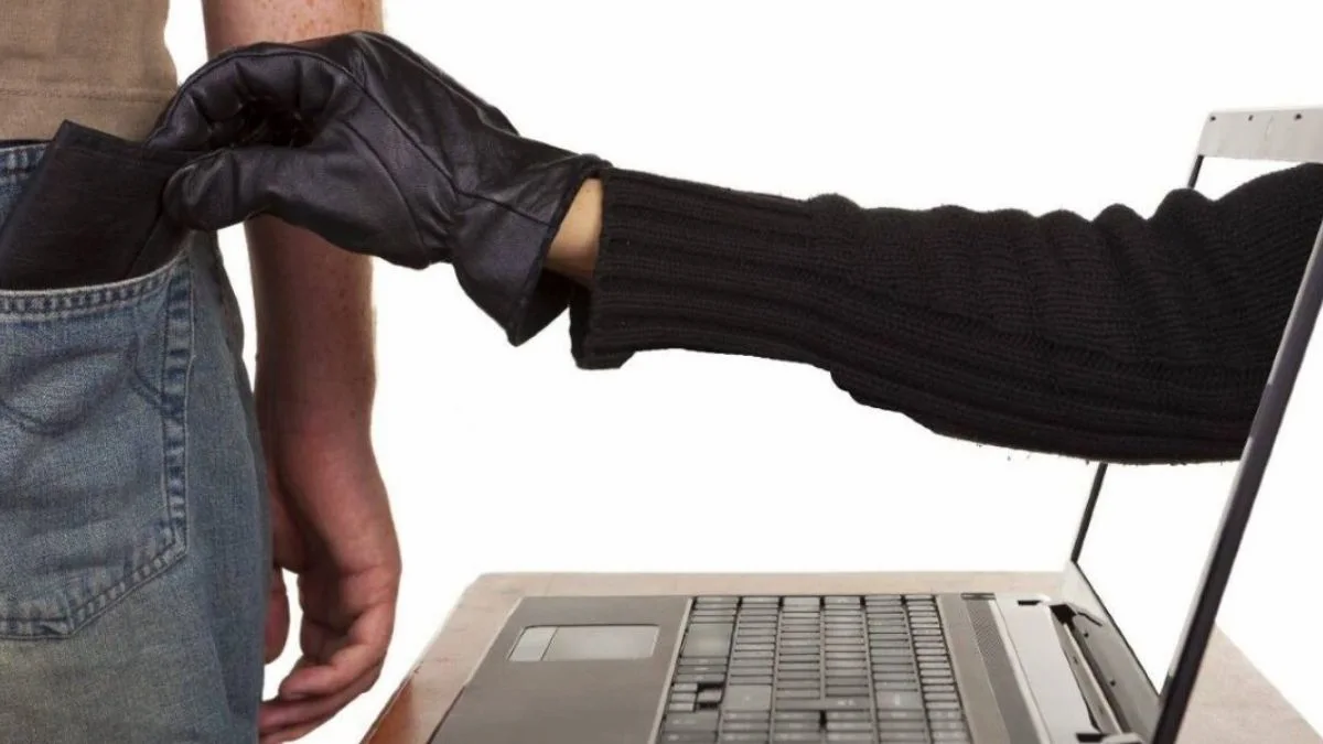A cada minuto, quatro golpes digitais são aplicados no Brasil - Uma mão enluvada sai de uma tela de notebook e rouba a carteira do bolso traseiro de uma pessoa.