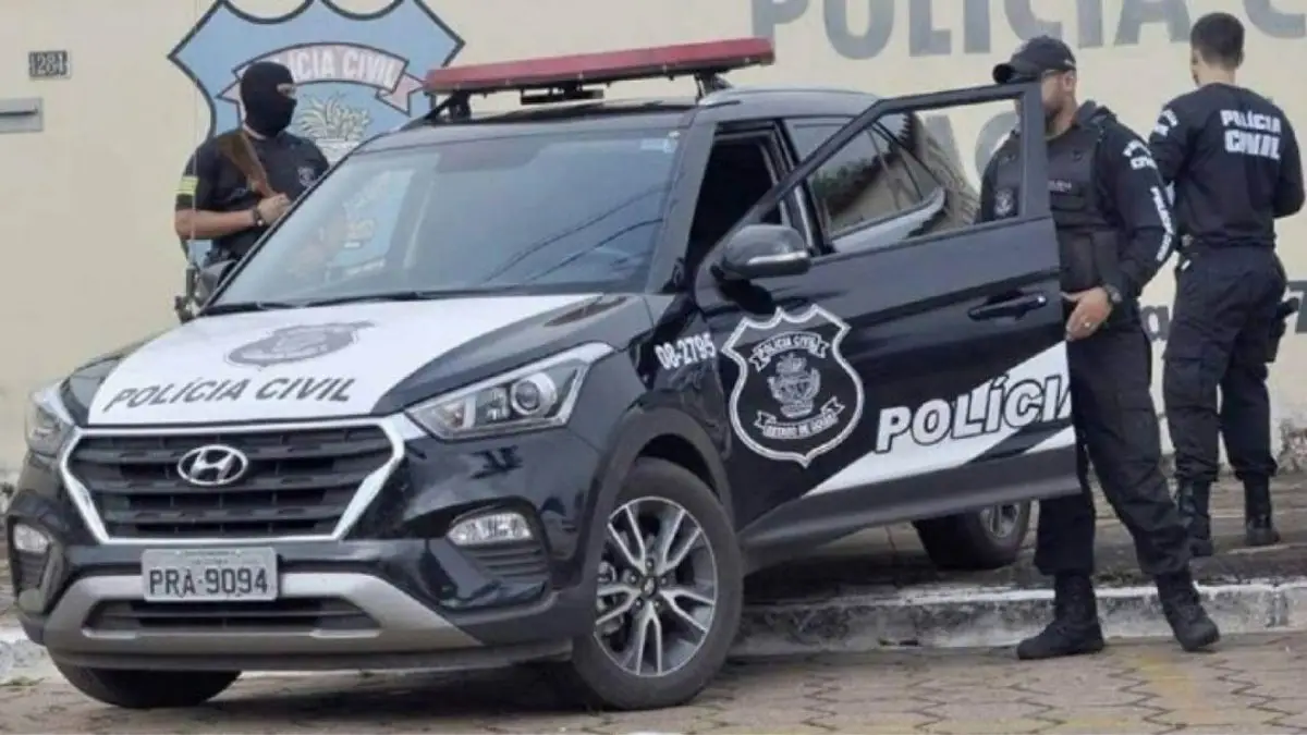 PCGO evita golpe de R$ 41 milhões-A imagem mostra uma viatura da **Polícia Civil**, modelo Hyundai, estacionada em frente a um prédio institucional. Policiais civis, alguns armados e uniformizados, estão ao redor do veículo durante uma operação.