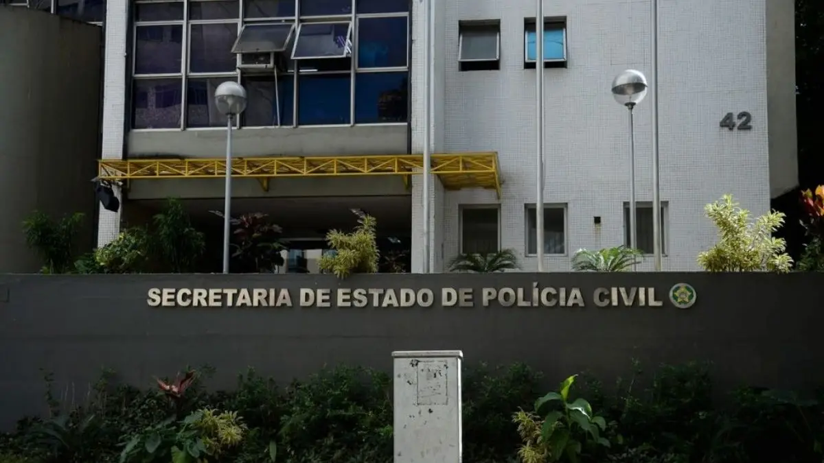 Fornecedor de Tecnologia para facções é preso -Fachada de prédio oficial com a identificação “Secretaria de Estado de Polícia Civil”, acompanhada de jardins e bandeiras na entrada.