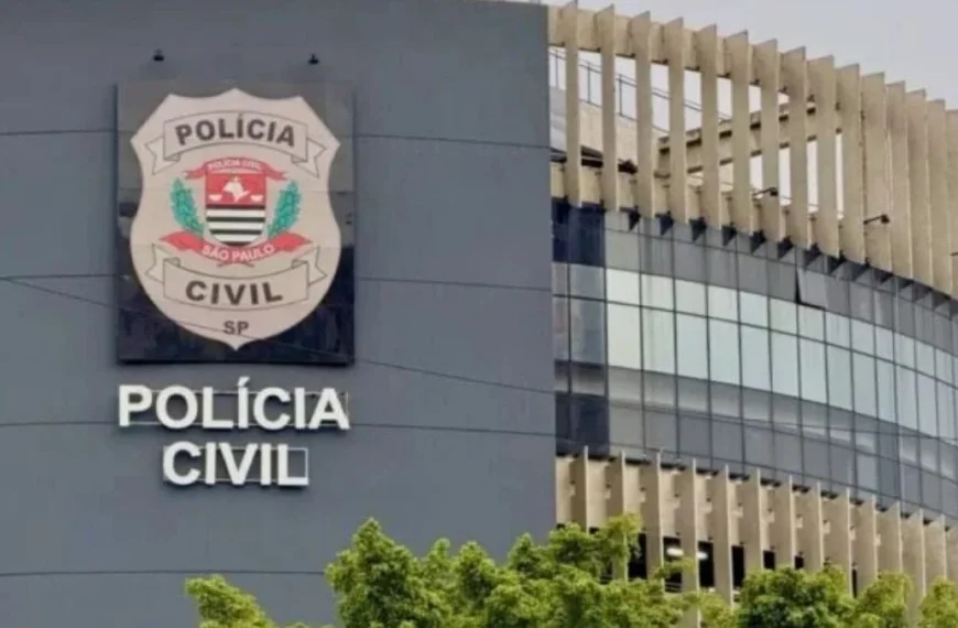 SP: Lei Orgânica da PC não avança-A imagem mostra a fachada de um prédio da Polícia Civil de São Paulo, com o brasão oficial da corporação em destaque na parede, acompanhado da inscrição "Polícia Civil". A construção tem design moderno, com vidros espelhados e elementos arquitetônicos verticais na parte externa.