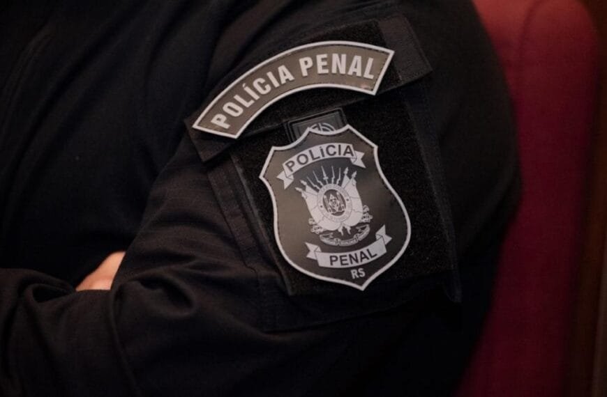 Farda preta com emblema da Polícia Penal do Rio Grande do Sul no braço de um agente.