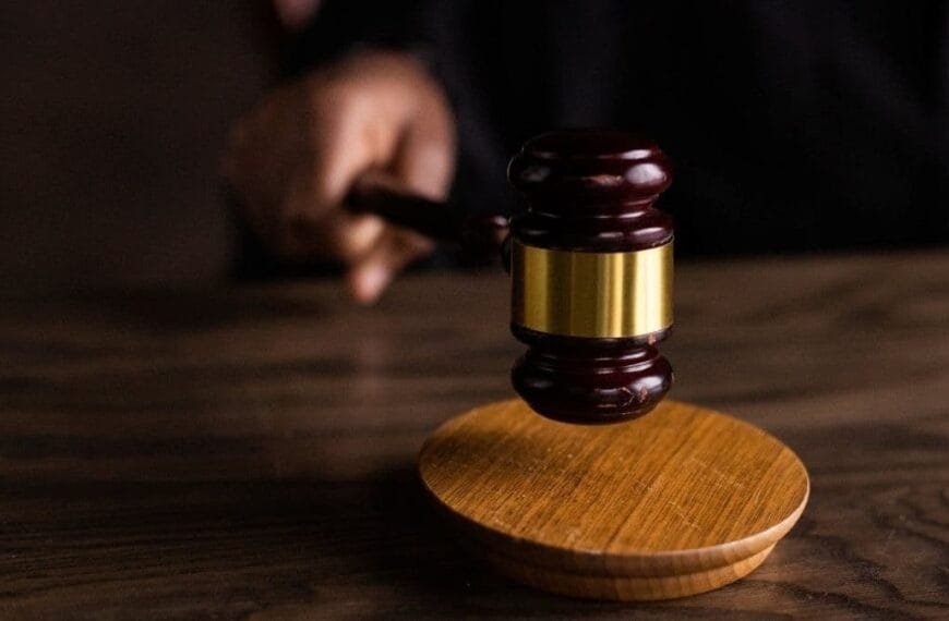 Quando a justiça desestimula a polícia-Close de um martelo de juiz em madeira, prestes a bater sobre a base circular em uma mesa de tribunal.