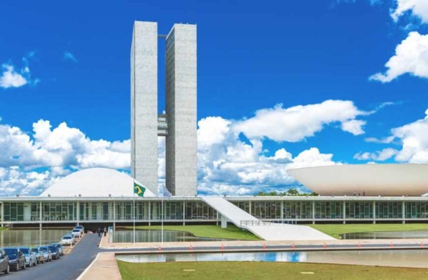 Comissão Especial da PEC-Fachada do Congresso Nacional em Brasília, com as duas torres do edifício ao centro e as cúpulas do Senado (à esquerda) e da Câmara dos Deputados (à direita), sob céu azul com nuvens.