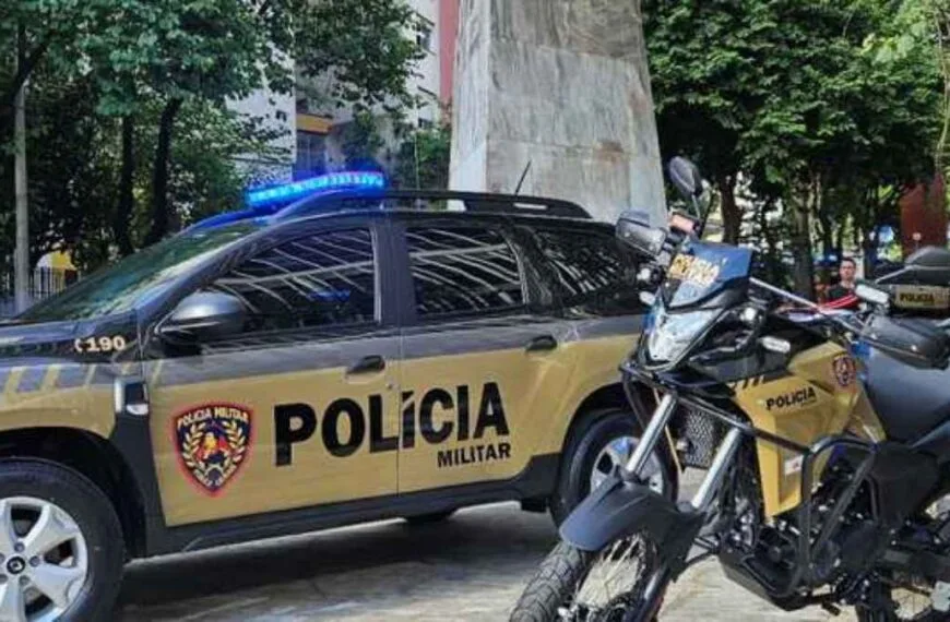 Viatura e motocicleta da Polícia Militar estacionadas em área urbana, com sirenes ligadas e identificação oficial visível.