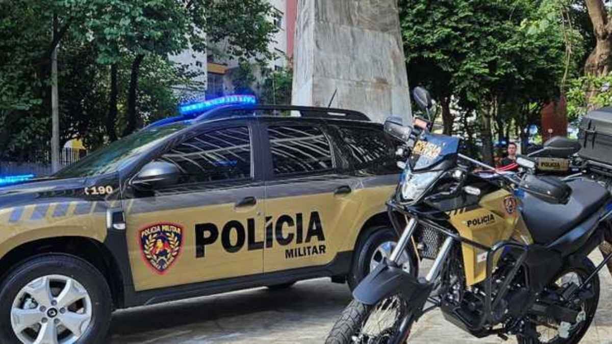 Viatura e motocicleta da Polícia Militar estacionadas em área urbana, com sirenes ligadas e identificação oficial visível.