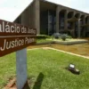 Ministério da Justiça: Pós-Graduação em fronteira e biomas-A imagem mostra a fachada do Palácio da Justiça, em Brasília. Em primeiro plano há uma placa marrom indicando “Palácio da Justiça / Justice Palace”.