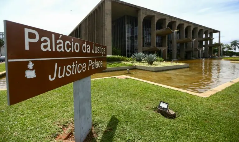 Ministério da Justiça: Pós-Graduação em fronteira e biomas-A imagem mostra a fachada do Palácio da Justiça, em Brasília. Em primeiro plano há uma placa marrom indicando “Palácio da Justiça / Justice Palace”.