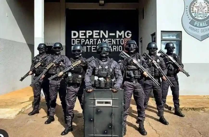 Avanço da terceirização na Polícia Penal-A imagem mostra um grupo de policiais penais fortemente armados e equipados, posicionados em frente a um prédio do Departamento Penitenciário de Minas Gerais (DEPEN-MG).