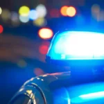 Luzes azuis de uma viatura policial acesas durante a noite, com o fundo desfocado, ilustrando matéria sobre aposentadoria e direitos previdenciários de policiais anteriores à Reforma da Previdência de 2019.