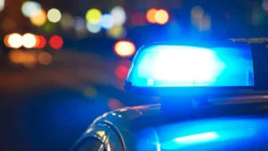 Luzes azuis de uma viatura policial acesas durante a noite, com o fundo desfocado, ilustrando matéria sobre aposentadoria e direitos previdenciários de policiais anteriores à Reforma da Previdência de 2019.