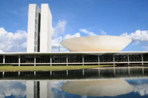 PEC24/2024: Prédio do Congresso Nacional, em Brasília, com as torres do Parlamento e a cúpula do Senado refletidas no espelho d'água