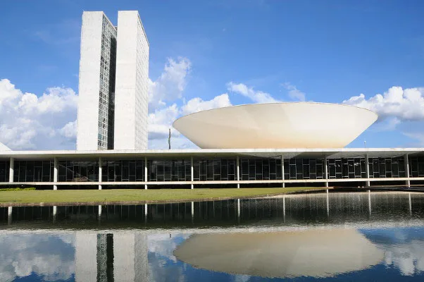 PEC24/2024: Prédio do Congresso Nacional, em Brasília, com as torres do Parlamento e a cúpula do Senado refletidas no espelho d'água