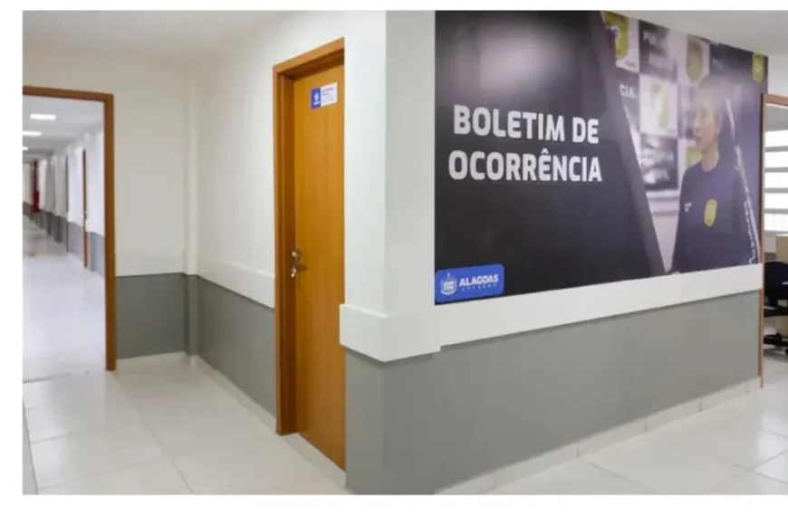 Corredor interno de uma Central de Flagrantes em Alagoas, com portas de atendimento e painel na parede indicando a área de registro de boletim de ocorrência (falsas comunicações de crimes)
