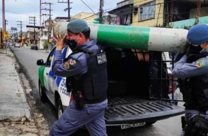 Policiais militares transportam cilindro de oxigênio durante ação de apoio à população em período da pandemia de Covid-19 em área urbana.